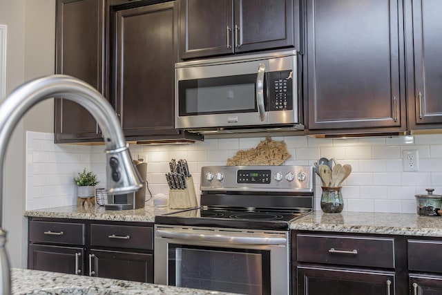 kitchen with stainless steel appliances, dark brown cabinets, and tasteful backsplash