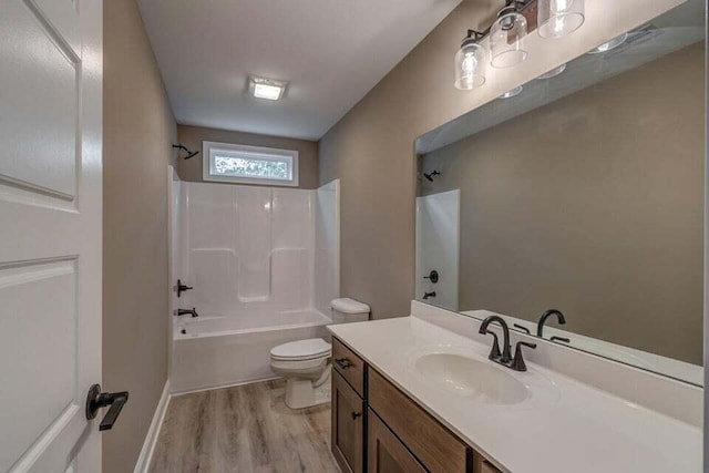 bathroom featuring wood finished floors, tub / shower combination, vanity, and toilet