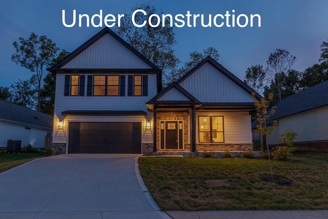 view of front facade featuring driveway, stone siding, an attached garage, central air condition unit, and a front yard