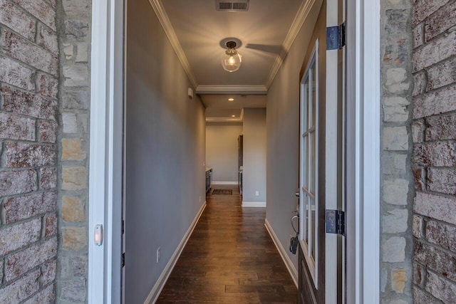 hall featuring ornamental molding, wood finished floors, visible vents, and baseboards