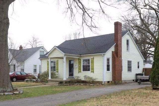 view of front facade featuring crawl space and a chimney