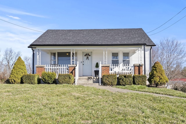 bungalow-style home with brick siding, a porch, a shingled roof, and a front lawn