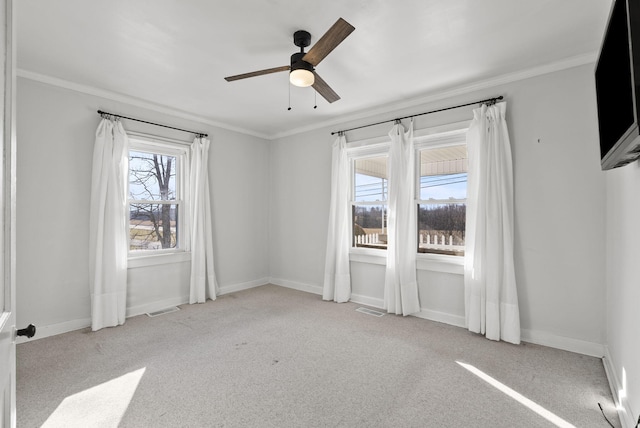 spare room with visible vents, baseboards, and crown molding