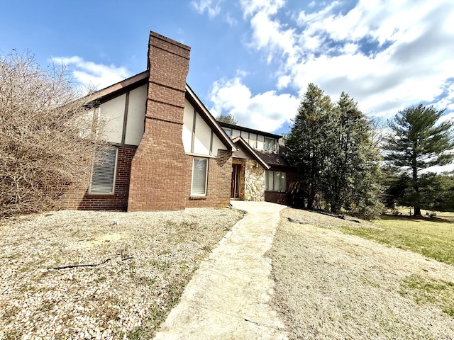 exterior space featuring brick siding and a chimney