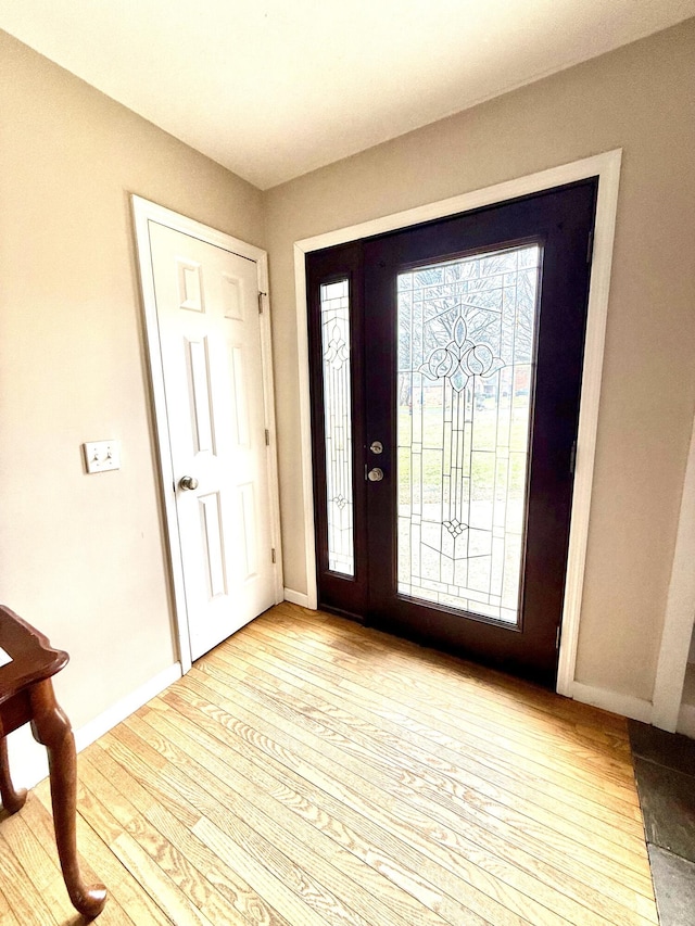 foyer entrance featuring light wood-type flooring and baseboards