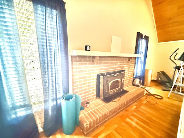 living room with a wood stove, plenty of natural light, and wood finished floors