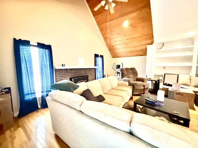 living area featuring wooden ceiling, ceiling fan, wood finished floors, vaulted ceiling, and a fireplace