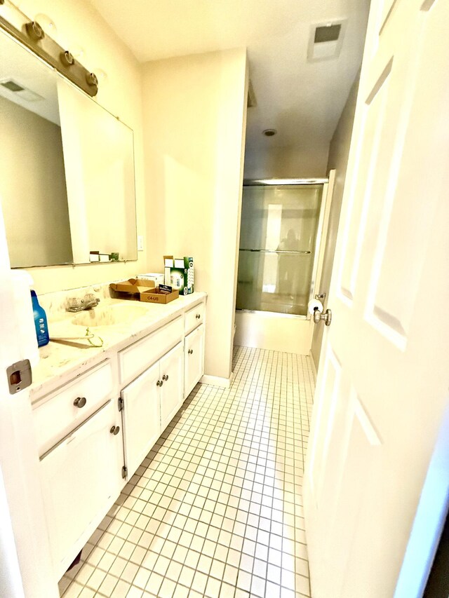 full bath featuring enclosed tub / shower combo, tile patterned flooring, visible vents, and vanity