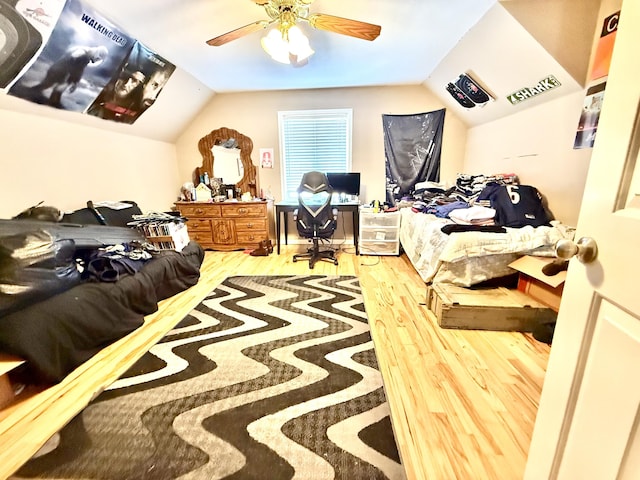 bedroom with lofted ceiling, a ceiling fan, and wood finished floors