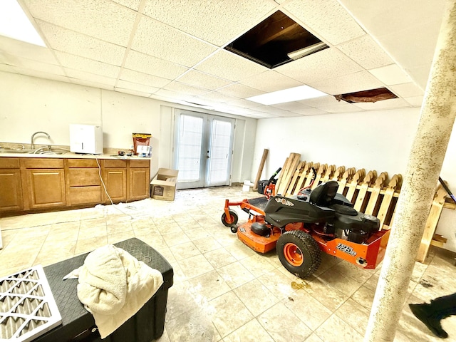 misc room with french doors, light tile patterned flooring, a sink, and a paneled ceiling