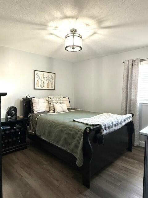 bedroom featuring a textured ceiling and wood finished floors