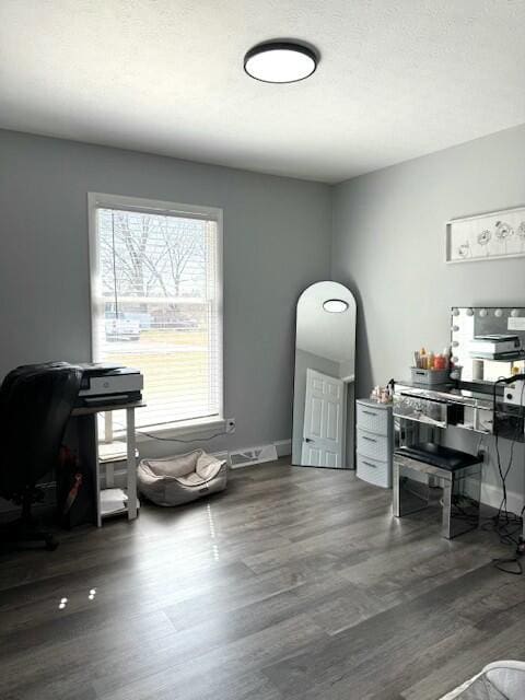 office featuring a textured ceiling, baseboards, and wood finished floors