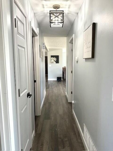 hall with baseboards and dark wood-style flooring