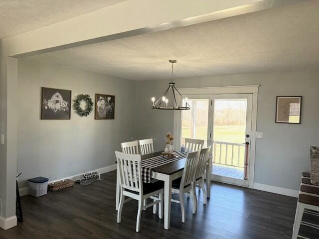 dining area with dark wood-style flooring, an inviting chandelier, and baseboards