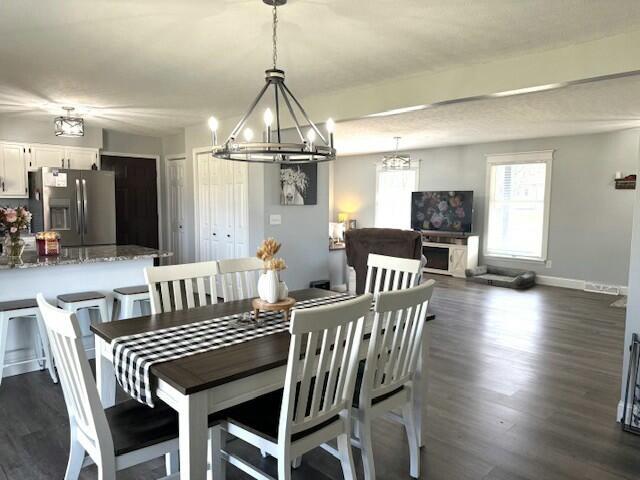 dining area with dark wood-style floors and baseboards