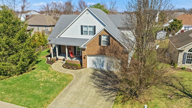 view of front of home featuring brick siding, a front yard, covered porch, driveway, and an attached garage