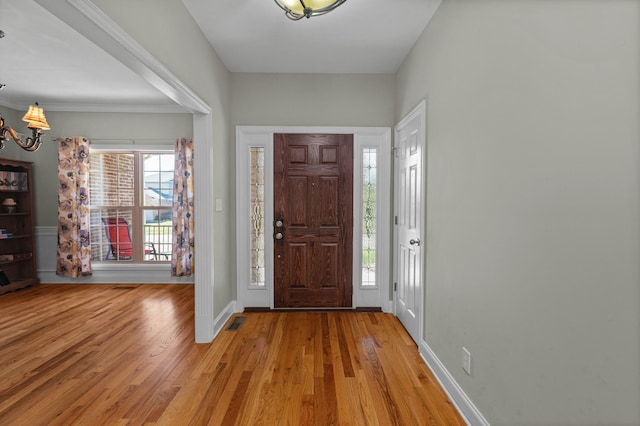 foyer entrance with baseboards, plenty of natural light, and light wood-style flooring