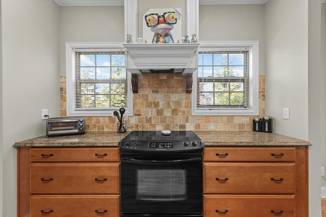 kitchen featuring tasteful backsplash, black range with electric cooktop, premium range hood, a toaster, and brown cabinets