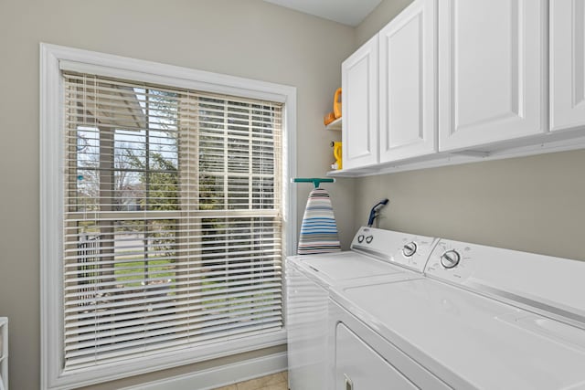 clothes washing area featuring cabinet space and separate washer and dryer