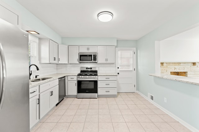 kitchen featuring visible vents, backsplash, a healthy amount of sunlight, appliances with stainless steel finishes, and a sink