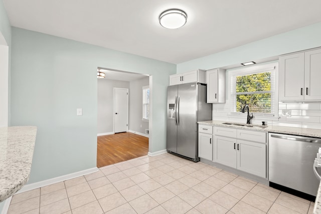 kitchen with decorative backsplash, a healthy amount of sunlight, appliances with stainless steel finishes, and a sink