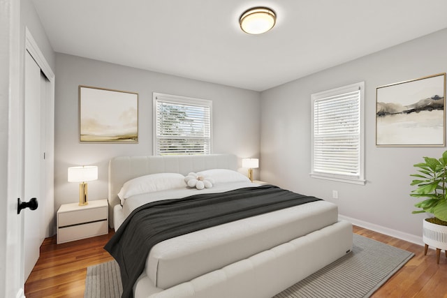 bedroom with a closet, baseboards, and wood finished floors