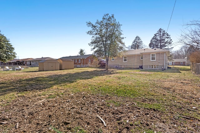 view of yard with an outdoor structure, a storage unit, and fence