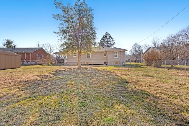 rear view of property with a lawn and fence