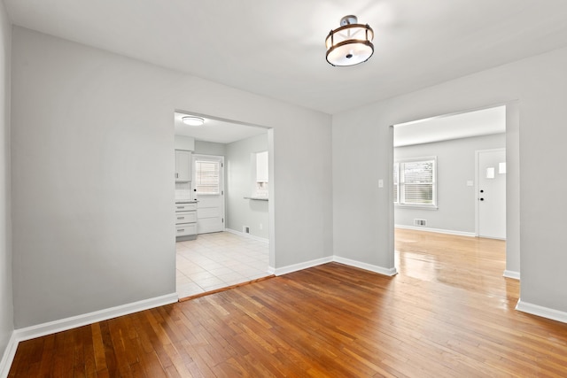 spare room with visible vents, baseboards, and light wood-type flooring