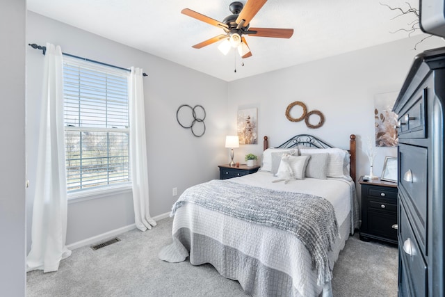 bedroom featuring a ceiling fan, light colored carpet, visible vents, and baseboards