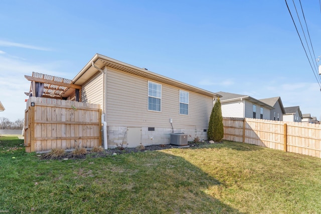 back of house featuring crawl space, cooling unit, fence, and a lawn