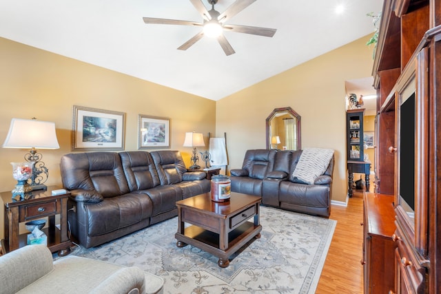 living area with vaulted ceiling, a ceiling fan, and light wood-style floors