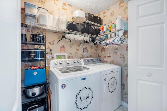 clothes washing area featuring a textured ceiling, laundry area, washing machine and dryer, and wallpapered walls