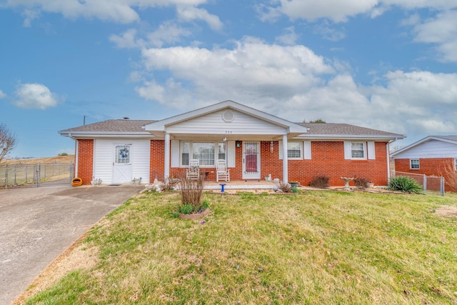 ranch-style house with a gate, brick siding, fence, and a front lawn