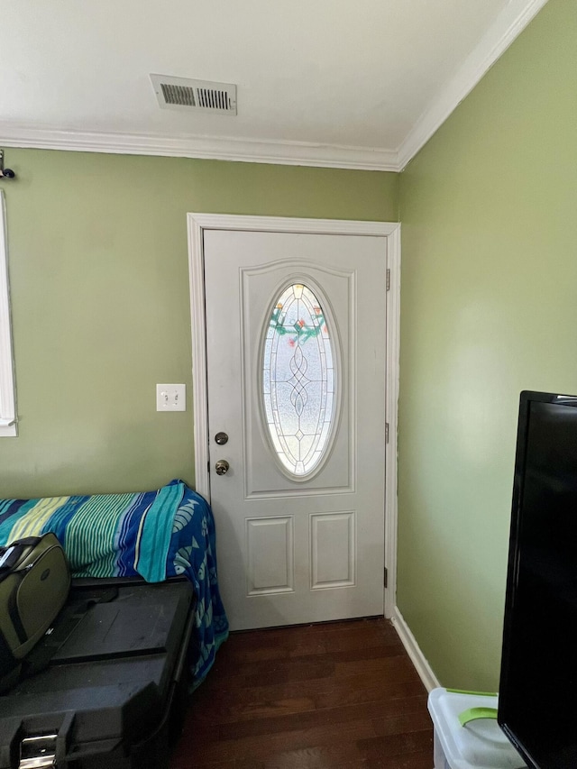 foyer featuring dark wood finished floors, visible vents, crown molding, and baseboards