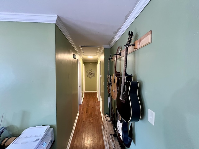 corridor featuring baseboards, attic access, wood finished floors, and crown molding