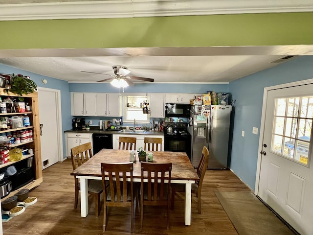 dining space with a ceiling fan, visible vents, and dark wood-style flooring