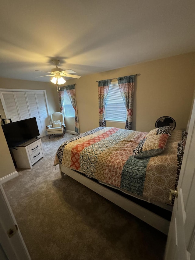 carpeted bedroom with ceiling fan and baseboards