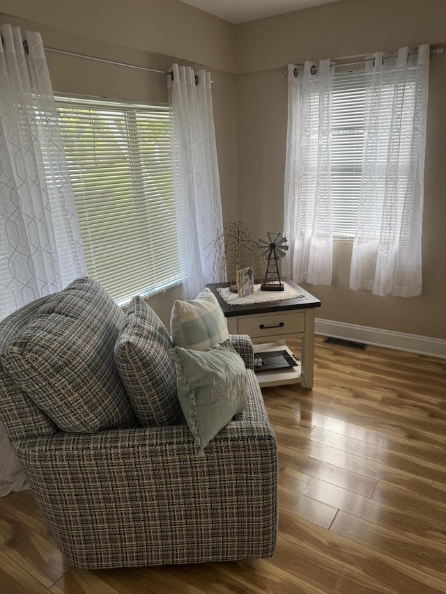 sitting room featuring visible vents, baseboards, and wood finished floors