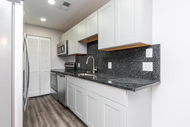 kitchen featuring a sink, visible vents, white cabinetry, appliances with stainless steel finishes, and dark wood-style floors