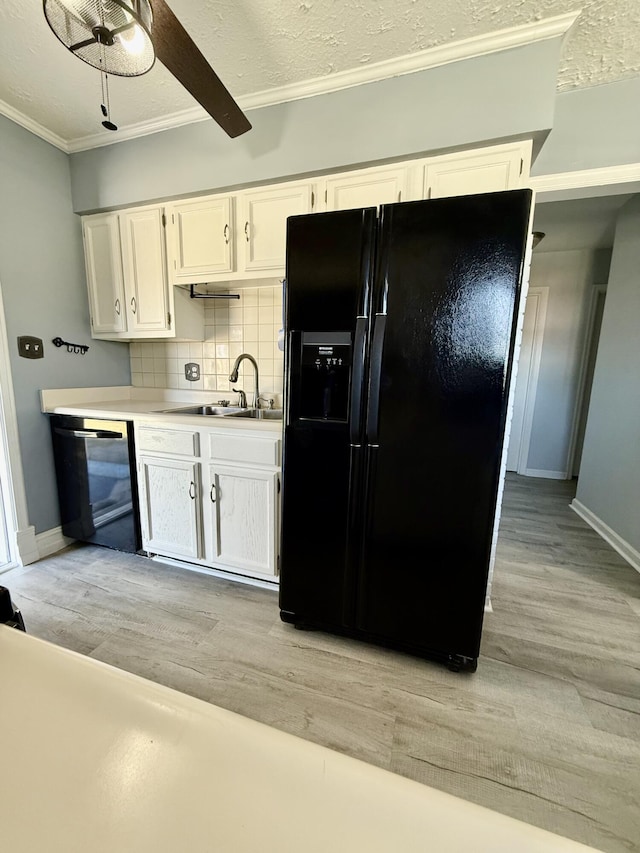 kitchen with ornamental molding, a sink, black appliances, white cabinetry, and backsplash