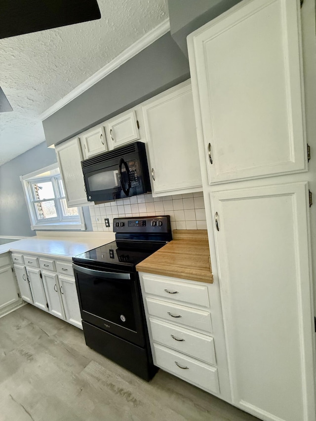 kitchen featuring a textured ceiling, light wood-style flooring, white cabinets, black appliances, and tasteful backsplash