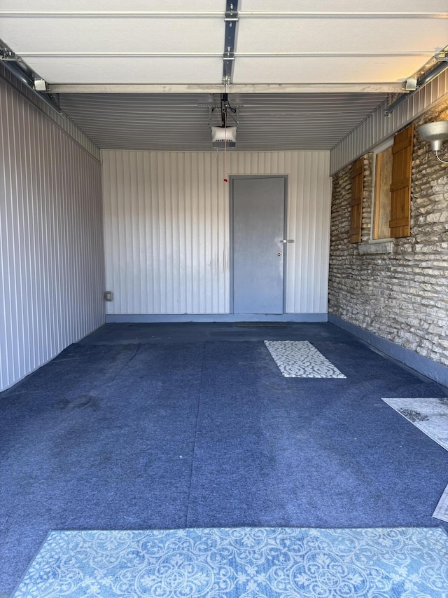 garage featuring metal wall and a garage door opener