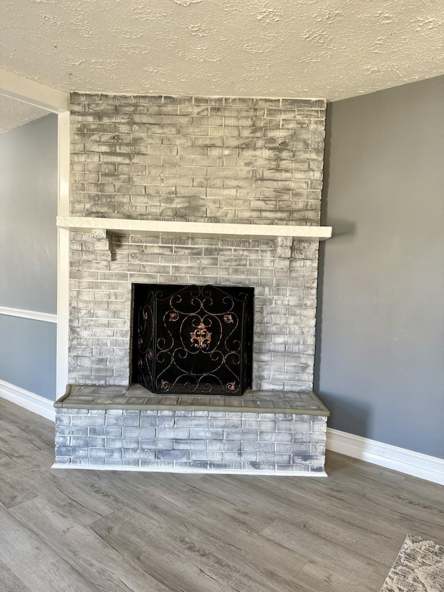 details with a fireplace, a textured ceiling, and wood finished floors