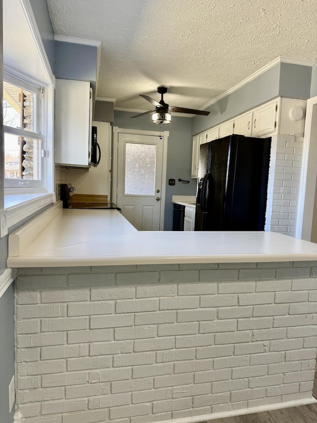 kitchen with electric range, black fridge with ice dispenser, a wealth of natural light, and white cabinets