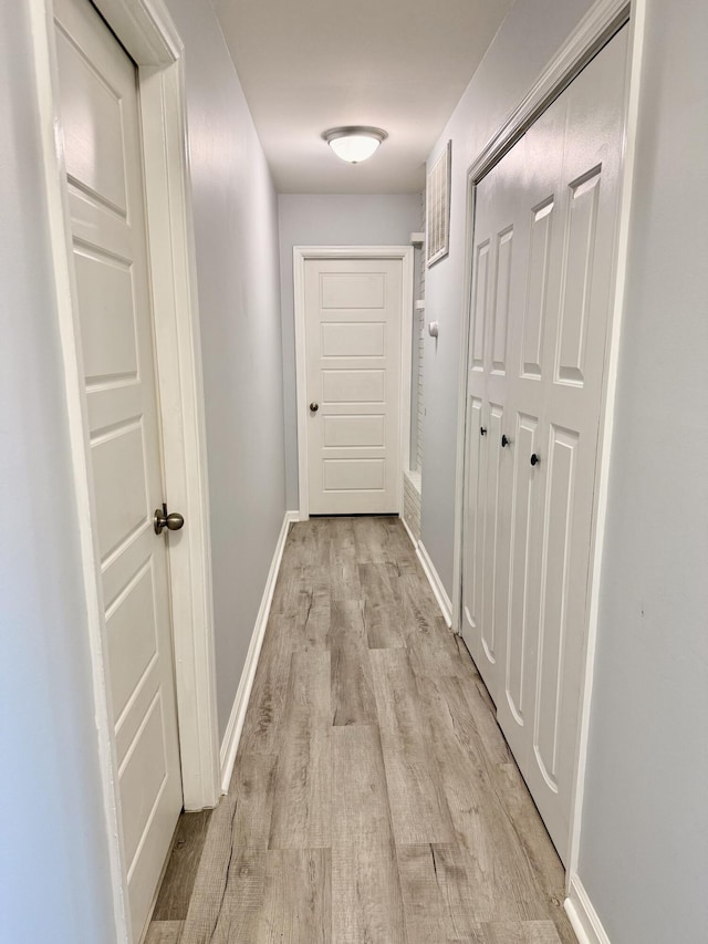 hallway with light wood finished floors and baseboards