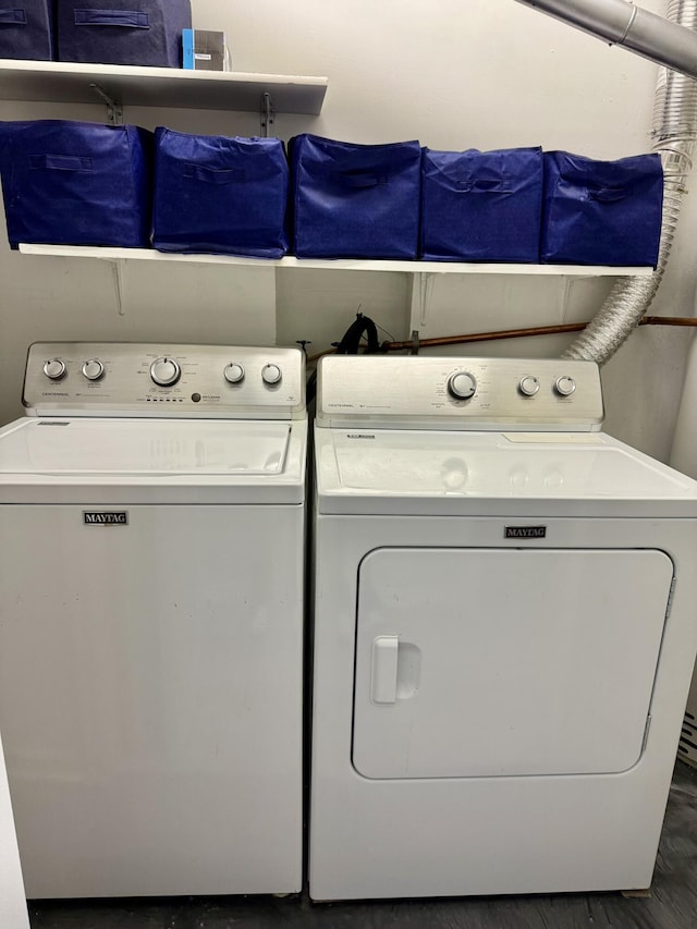 clothes washing area featuring laundry area, separate washer and dryer, and wood finished floors