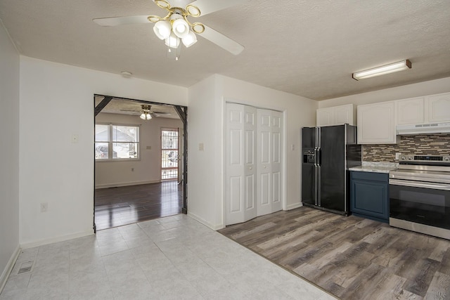 kitchen featuring a ceiling fan, electric stove, under cabinet range hood, backsplash, and black refrigerator with ice dispenser