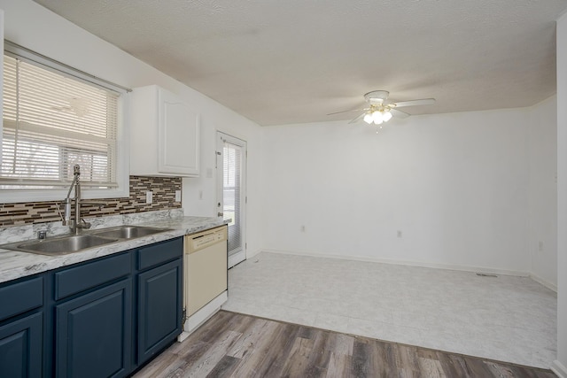 kitchen featuring a ceiling fan, a sink, dishwasher, blue cabinets, and backsplash