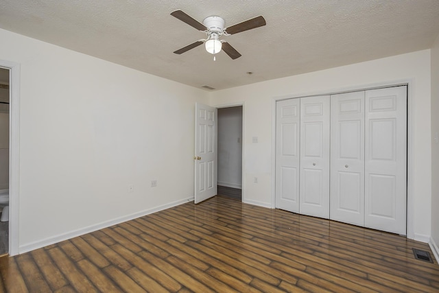 unfurnished bedroom featuring visible vents, a textured ceiling, wood finished floors, a closet, and baseboards